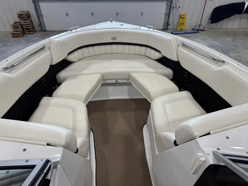 Slide: The Image of Interior of 2012 Cobalt A-25 boat with white leather seating in a garage. - 12