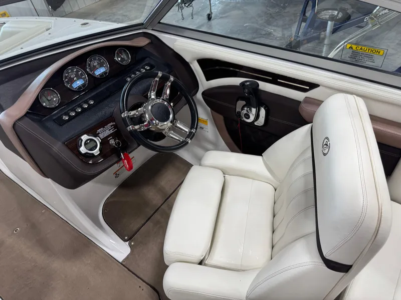 Slide: The Image of 2012 Cobalt A-25 boat cockpit with steering wheel and white captain's chair. - 15