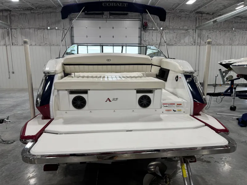 Slide: The Image of 2012 Cobalt A-25 boat in a garage, rear view with seating and speakers. - 5