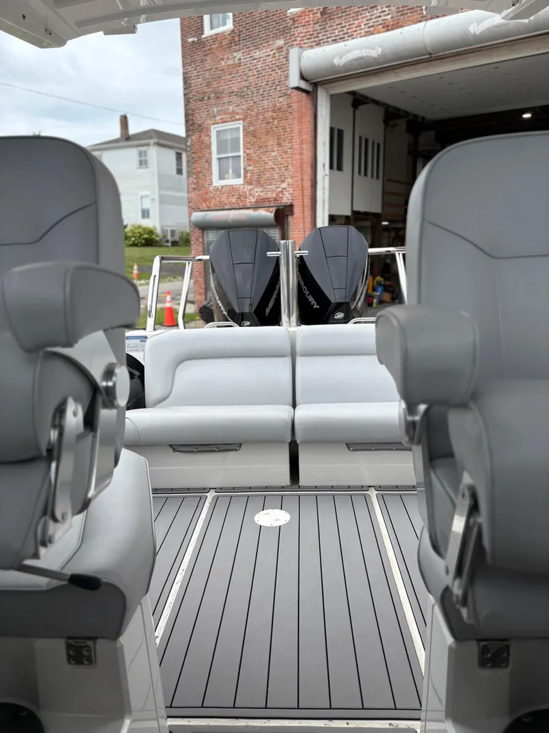 Slide: The Image of 2020 Protector 310 Targa boat interior with gray seating and dual outboard motors. - 22