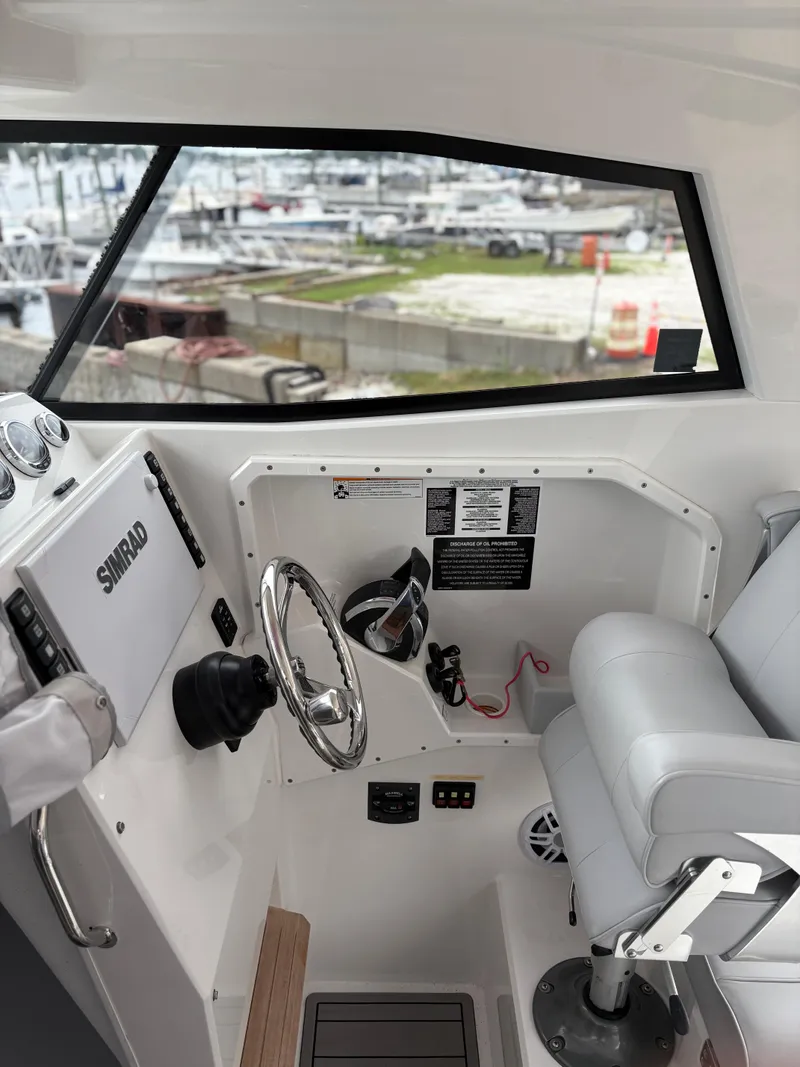 Slide: The Image of Interior of a 2020 Protector 310 Targa boat with steering wheel and controls. - 23