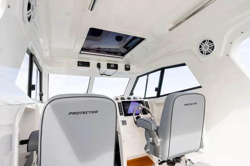Slide: The Image of Interior of 2020 Protector 310 Targa boat, featuring modern helm and seating. - 3