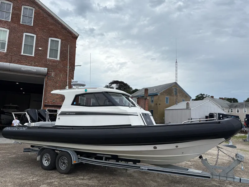 Slide: The Image of 2020 Protector 310 Targa boat on trailer, parked near brick building. - 5