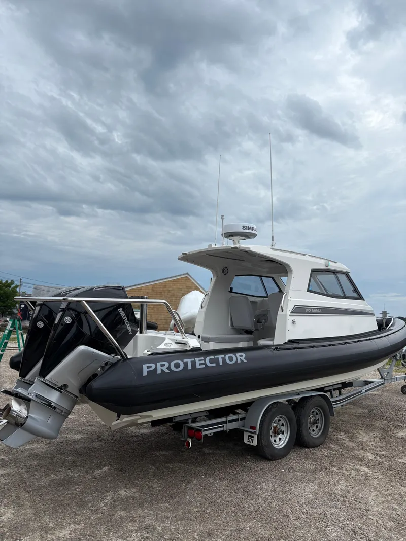 Slide: The Image of 2020 Protector 310 Targa boat on trailer under cloudy sky. - 6