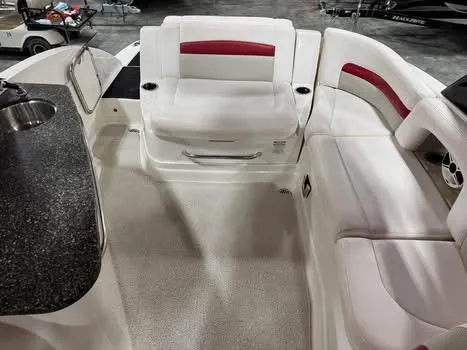 Slide: The Image of 2009 Chaparral 264 Sunesta boat interior with white and red seating, and a granite countertop. - 12