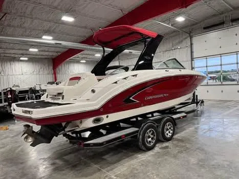 Slide: The Image of 2009 Chaparral 264 Sunesta boat with red and white design in a spacious indoor facility. - 5