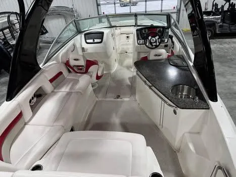 Slide: The Image of 2009 Chaparral 264 Sunesta boat interior with white seating and a compact kitchenette. - 8