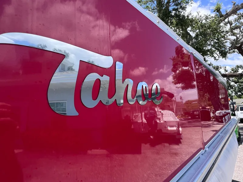 Slide: The Image of 2022 Tahoe Pontoon LTZ 2485 EL with reflective red exterior and chrome logo. - 11