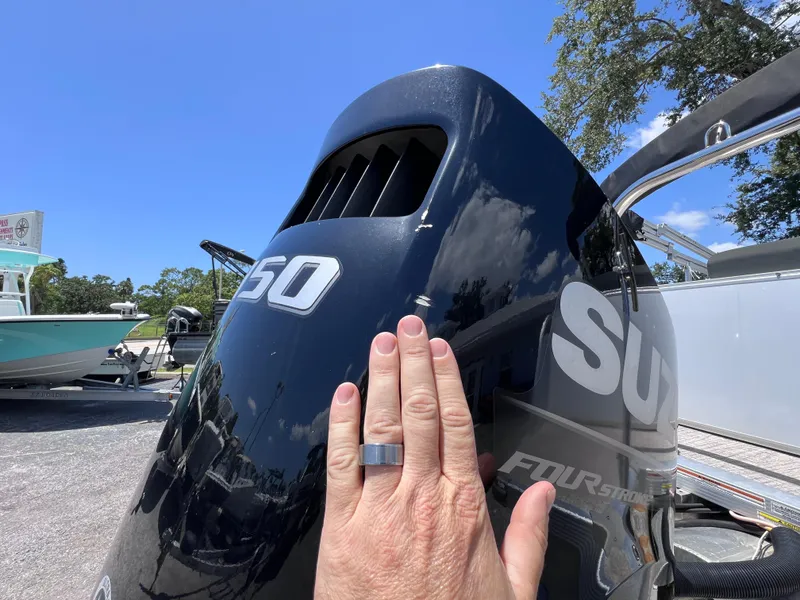 Slide: The Image of Hand touching Suzuki outboard motor on 2022 Tahoe Pontoon LTZ 2485 EL boat. - 14