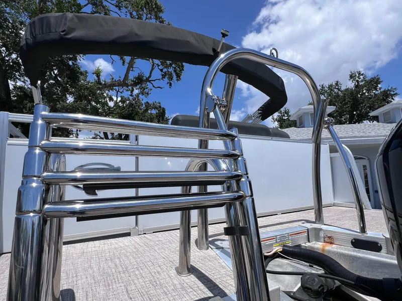 Slide: The Image of 2022 Tahoe Pontoon LTZ 2485 EL with stainless steel ladder and canopy under blue sky. - 15