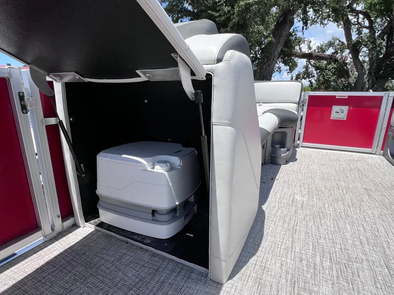 Slide: The Image of 2022 Tahoe Pontoon LTZ 2485 EL with onboard portable toilet, gray seating, and red paneling. - 27