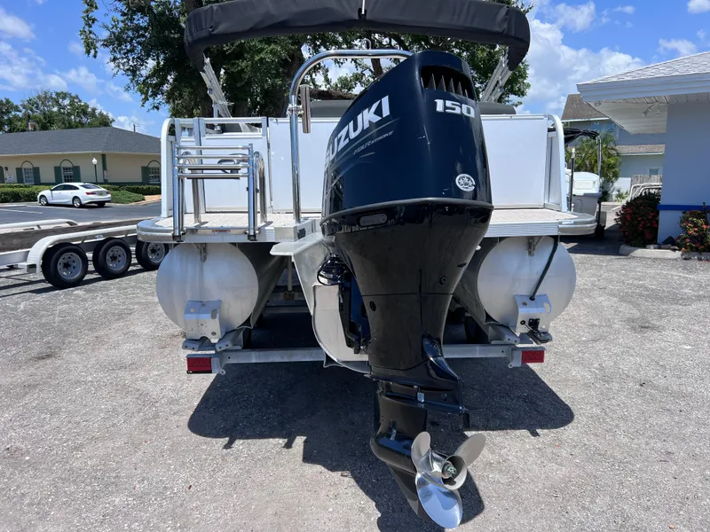 Slide: The Image of 2022 Tahoe Pontoon LTZ 2485 EL with Suzuki 150 outboard motor, parked on a trailer. - 3