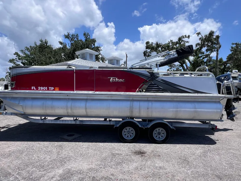 Slide: The Image of 2022 Tahoe Pontoon LTZ 2485 EL on trailer, red and silver, parked outdoors. - 5