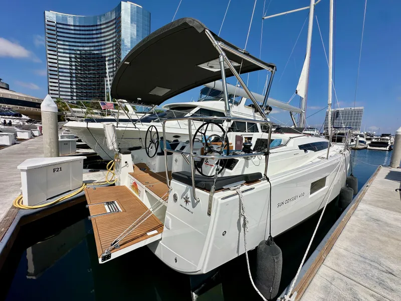 Slide: The Image of 2024 Jeanneau Sun Odyssey 410 yacht docked at marina, modern design, cityscape background. - 10