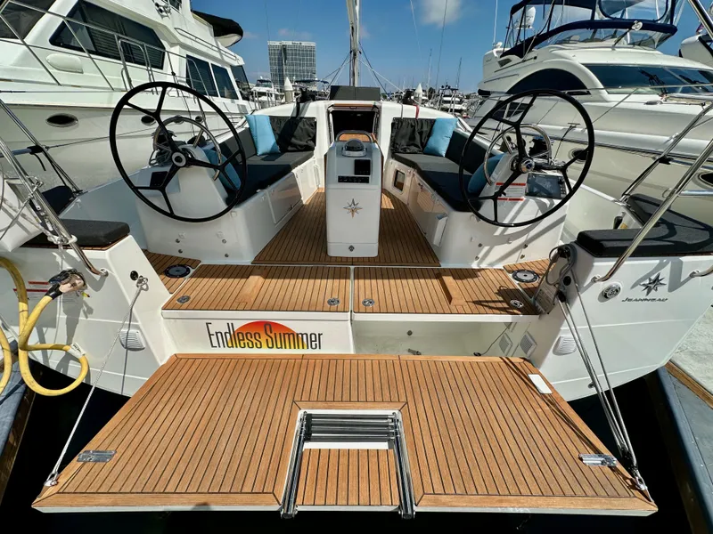Slide: The Image of 2024 Jeanneau Sun Odyssey 410 yacht with dual steering wheels and teak deck in marina. - 12