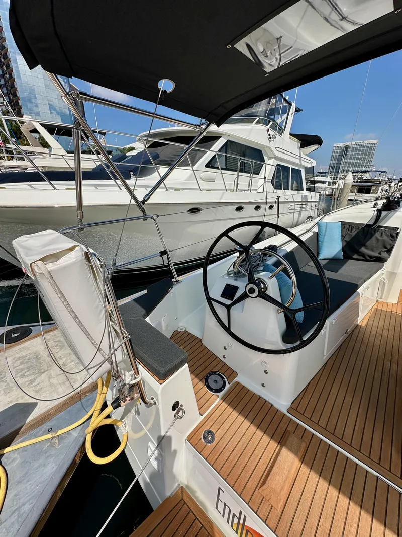 Slide: The Image of 2024 Jeanneau Sun Odyssey 410 sailboat cockpit with steering wheel, docked at marina. - 13