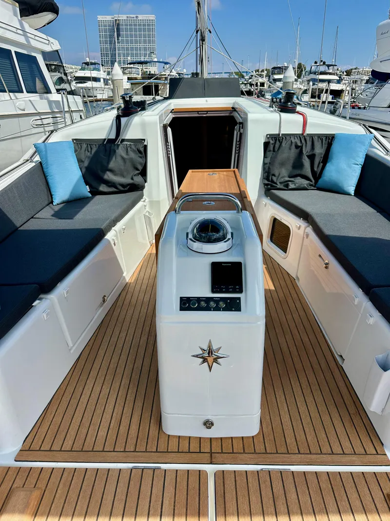 Slide: The Image of 2024 Jeanneau Sun Odyssey 410 yacht cockpit with teak flooring and modern navigation equipment. - 14