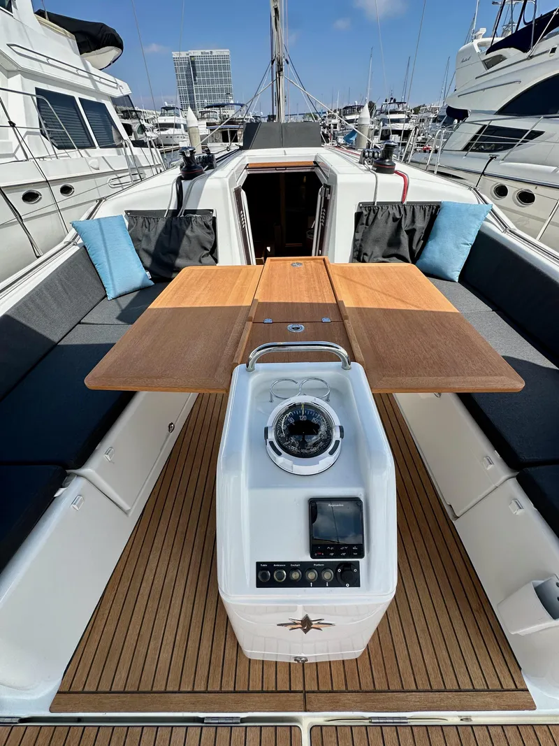 Slide: The Image of 2024 Jeanneau Sun Odyssey 410 yacht cockpit with wooden table and navigation instruments. - 21