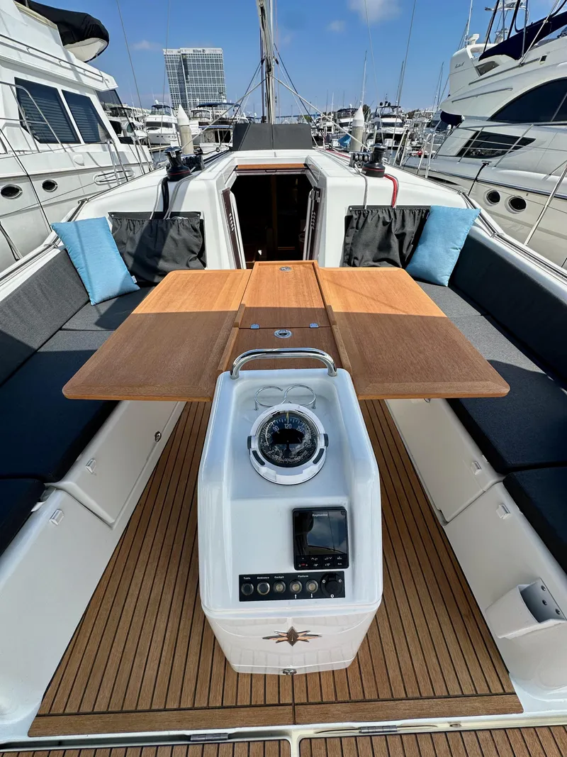 Slide: The Image of 2024 Jeanneau Sun Odyssey 410 cockpit with wooden table and navigation instruments. - 22