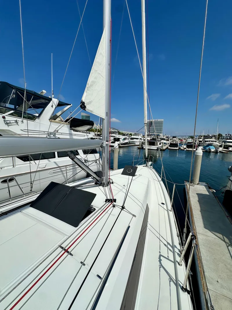 Slide: The Image of 2024 Jeanneau Sun Odyssey 410 sailboat docked in a marina under clear blue skies. - 29