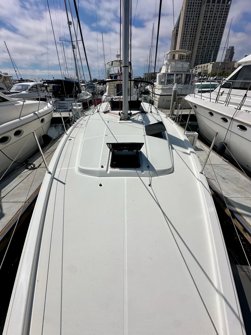Slide: The Image of 2024 Jeanneau Sun Odyssey 410 sailboat docked at marina, surrounded by other boats. - 35
