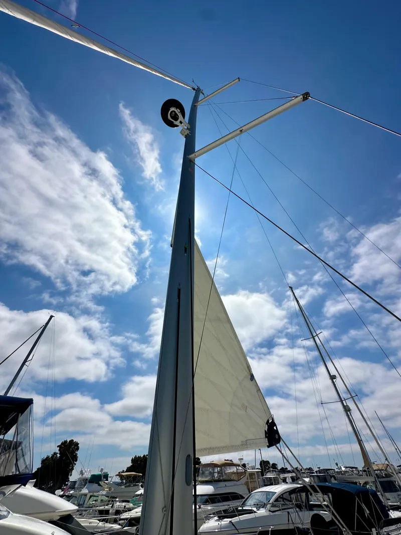 Slide: The Image of Sailboat mast and sail of 2024 Jeanneau Sun Odyssey 410 against a bright blue sky. - 37