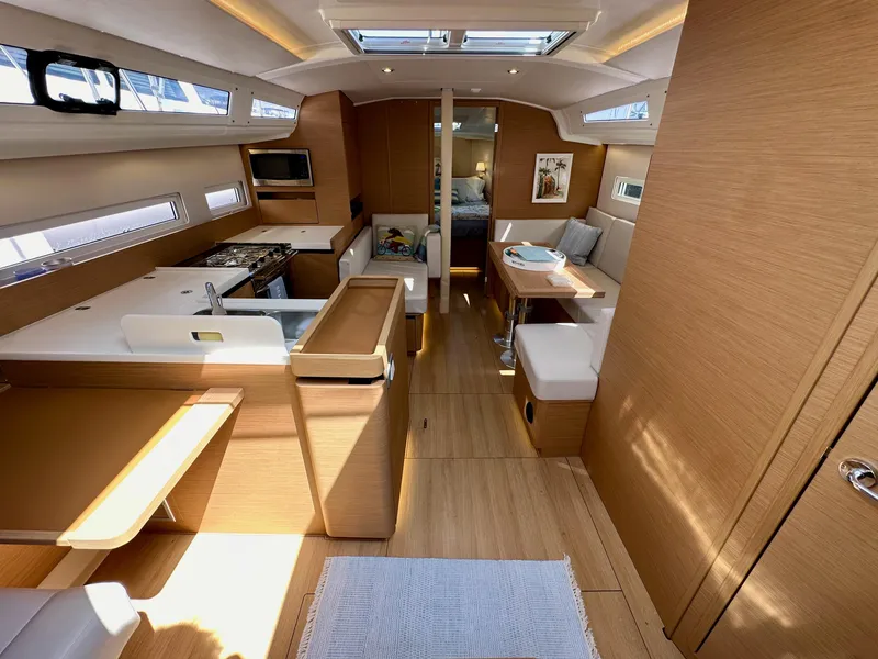 Slide: The Image of 2024 Jeanneau Sun Odyssey 410 interior with modern kitchen, dining area, and cozy seating. - 45