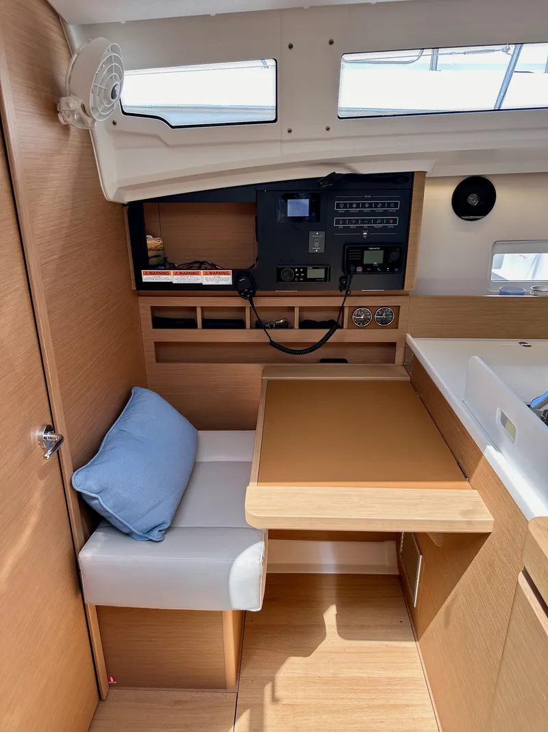 Slide: The Image of 2024 Jeanneau Sun Odyssey 410 interior with navigation station and seating area. - 47