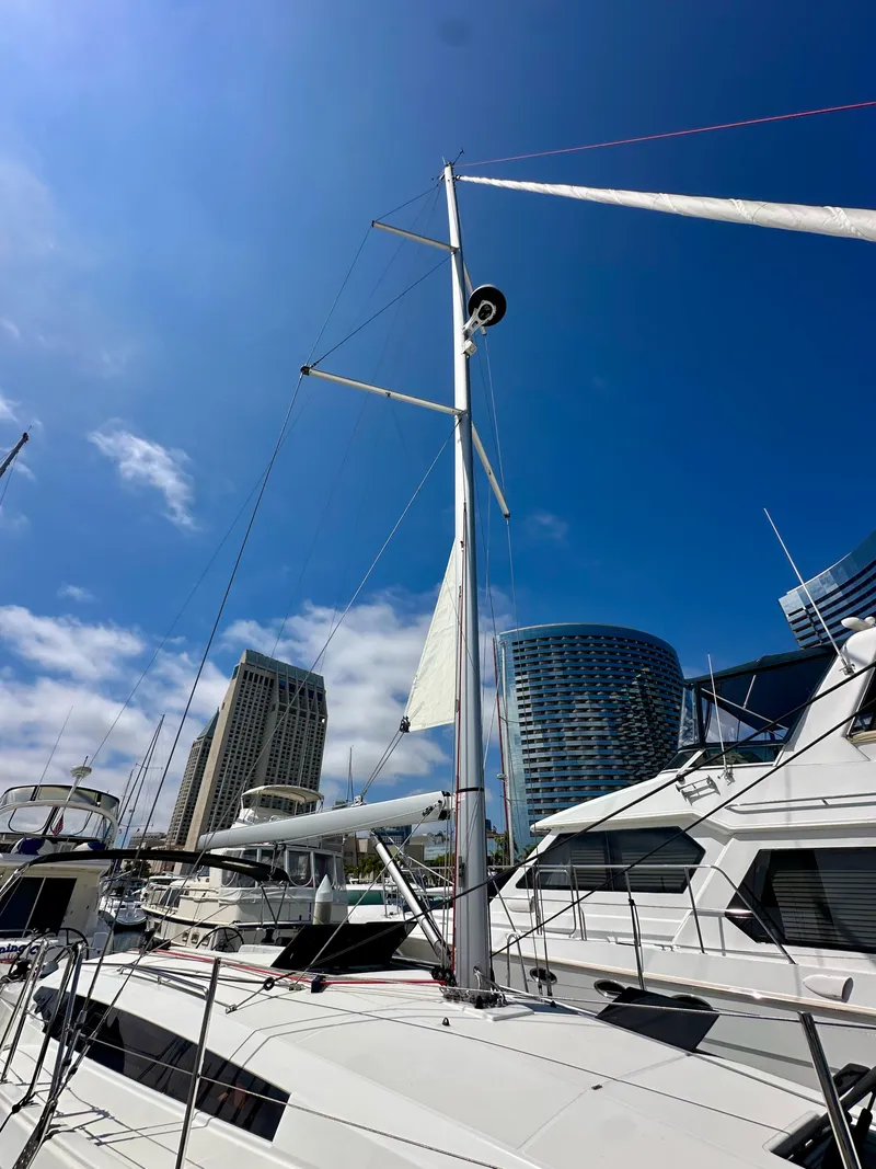 Slide: The Image of 2024 Jeanneau Sun Odyssey 410 sailboat docked in a marina under a clear blue sky. - 7
