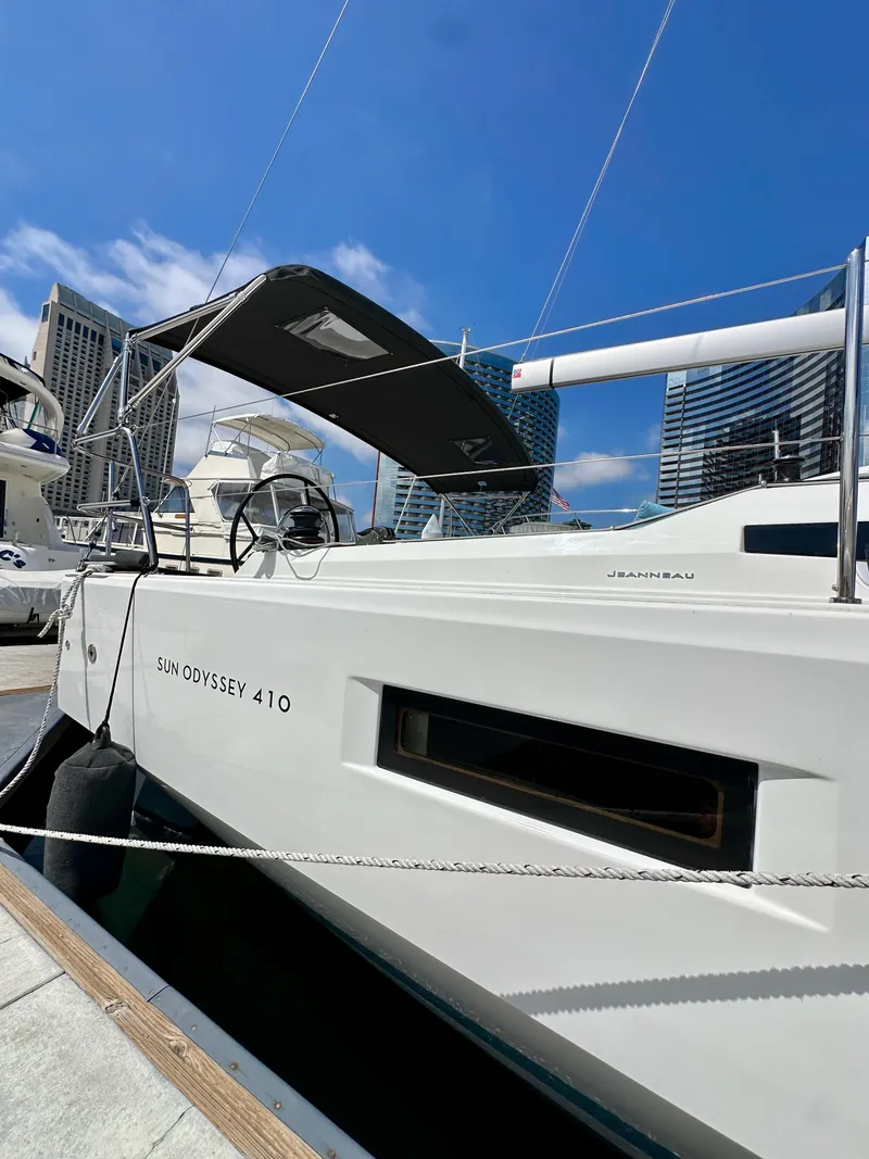 Slide: The Image of 2024 Jeanneau Sun Odyssey 410 yacht docked at marina under clear blue sky. - 9