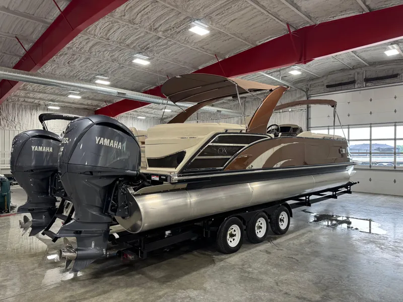 Slide: The Image of 2022 Bennington QX 30 pontoon boat with Yamaha engines in a spacious indoor facility. - 4