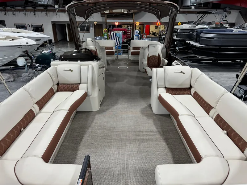 Slide: The Image of 2022 Bennington QX 30 pontoon boat interior with luxurious seating in showroom. - 6