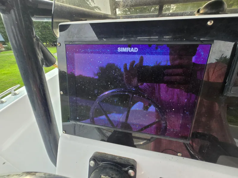 Slide: The Image of Simrad display on 1994 Grady-White Chase 263 boat dashboard, reflecting surroundings. - 12