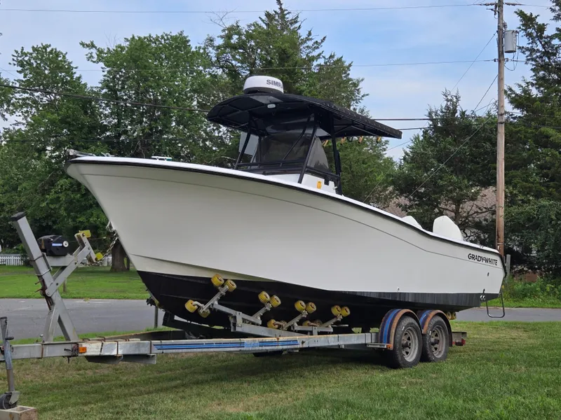 Slide: The Image of 1994 Grady-White Chase 263 boat on trailer, parked on grass, surrounded by trees. - 16