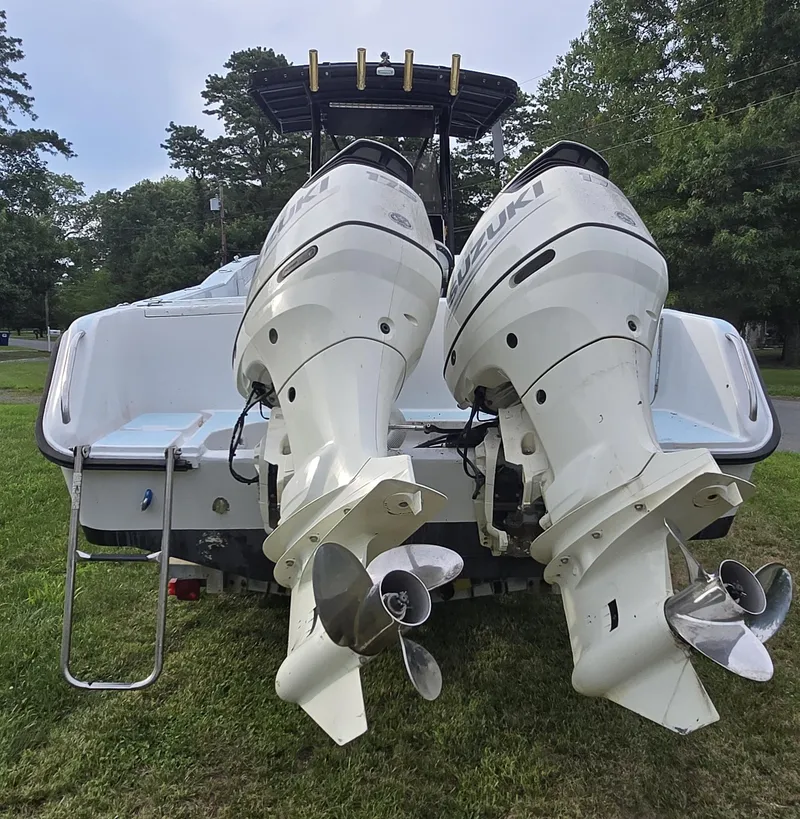 Slide: The Image of 1994 Grady-White Chase 263 boat with dual Suzuki outboard motors on grass. - 3