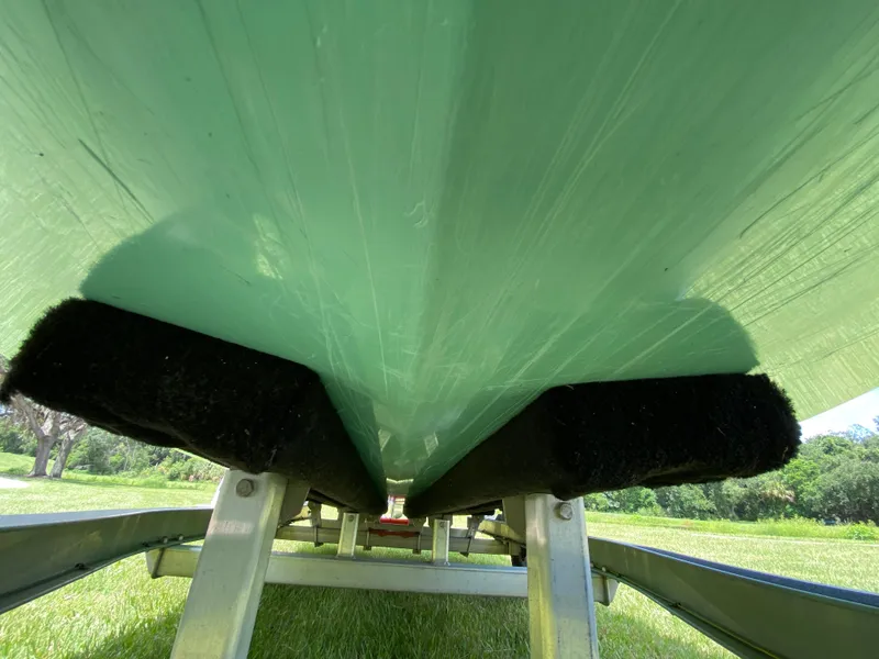 Slide: The Image of Underside view of 2020 East Cape 18 EVO boat on trailer, grassy background. - 10