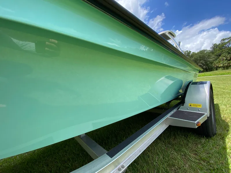 Slide: The Image of 2020 East Cape 18 EVO boat on trailer, green hull, sunny day. - 11