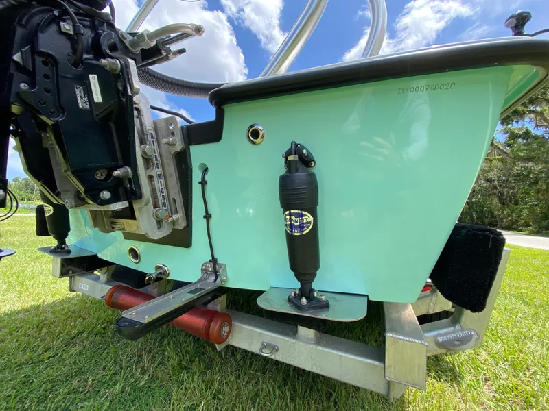 Slide: The Image of 2020 East Cape 18 EVO boat on trailer, showcasing motor and trim tab details. - 16