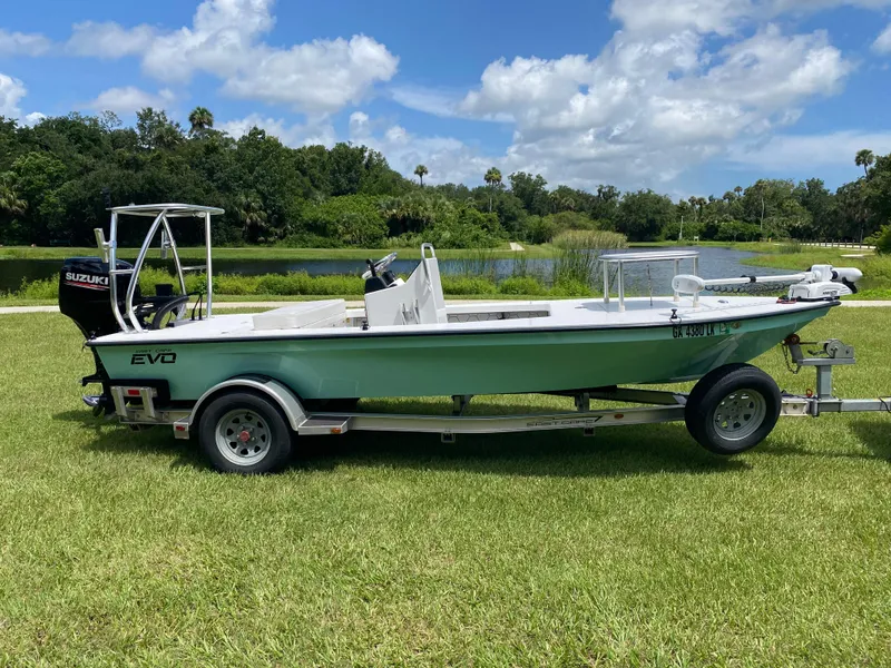 Slide: The Image of 2020 East Cape 18 EVO boat on trailer by a scenic lake. - 2