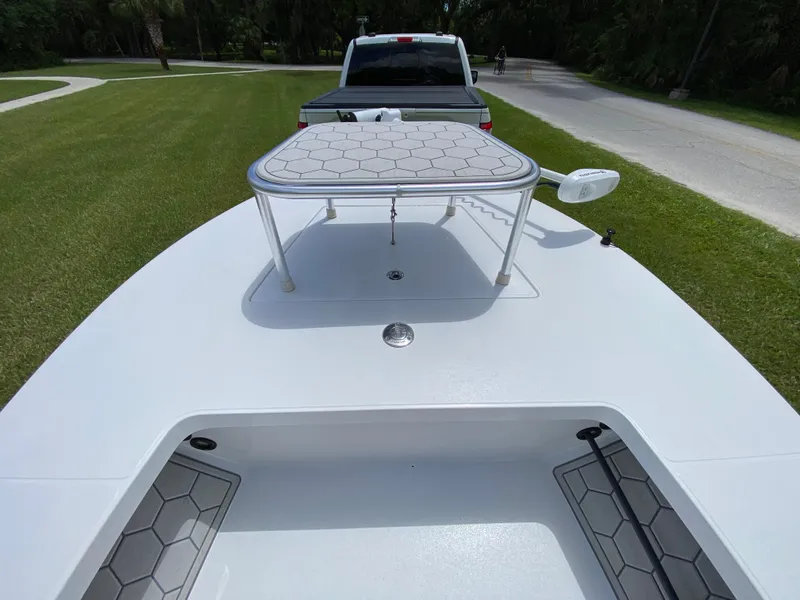 Slide: The Image of 2020 East Cape 18 EVO boat on trailer, parked on grass near a road. - 23