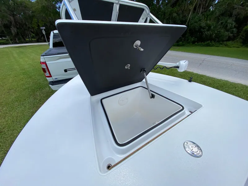 Slide: The Image of Open storage compartment on 2020 East Cape 18 EVO boat, parked near a grassy area. - 28