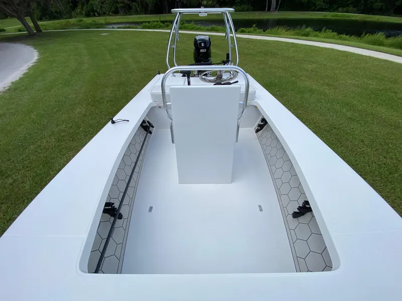 Slide: The Image of 2020 East Cape 18 EVO boat with hexagonal deck pattern, parked on grass. - 31