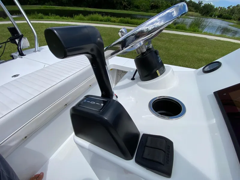 Slide: The Image of Control console of a 2020 East Cape 18 EVO boat, featuring steering wheel and throttle. - 40