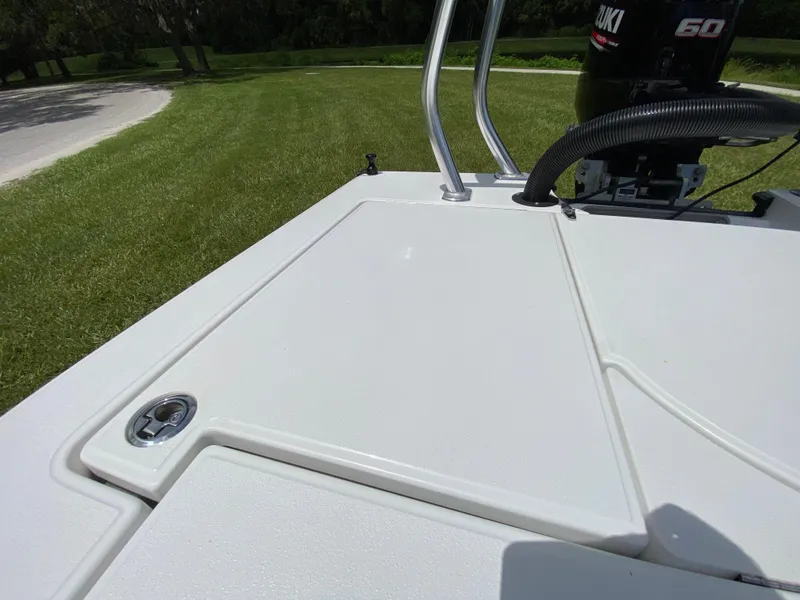 Slide: The Image of 2020 East Cape 18 EVO boat deck with Suzuki 60 engine, parked on grass. - 48