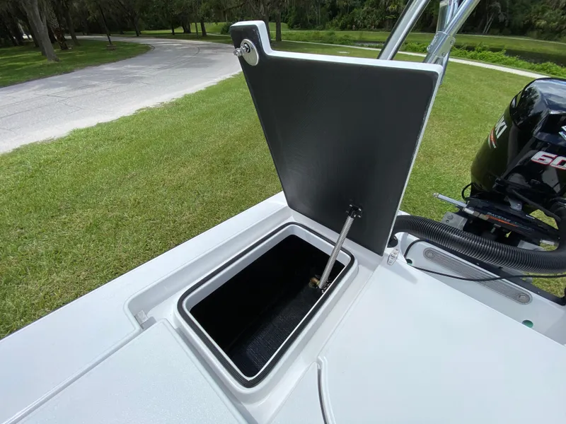 Slide: The Image of Open storage compartment on 2020 East Cape 18 EVO boat, with outboard motor visible. - 49