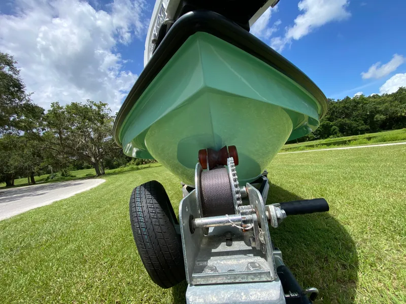 Slide: The Image of 2020 East Cape 18 EVO boat on trailer, grassy landscape, clear blue sky. - 7