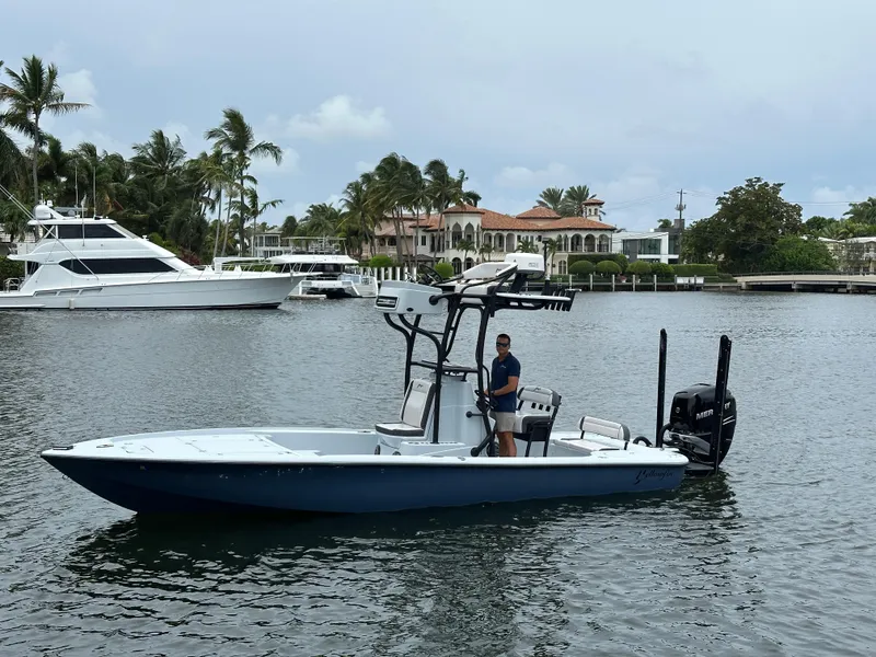 The Image of 2019 Yellowfin 24 Bay CE boat on water, with palm trees and luxury homes in background. - 0