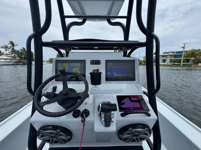 Slide: The Image of 2019 Yellowfin 24 Bay CE boat dashboard with steering wheel and navigation screens. - 10