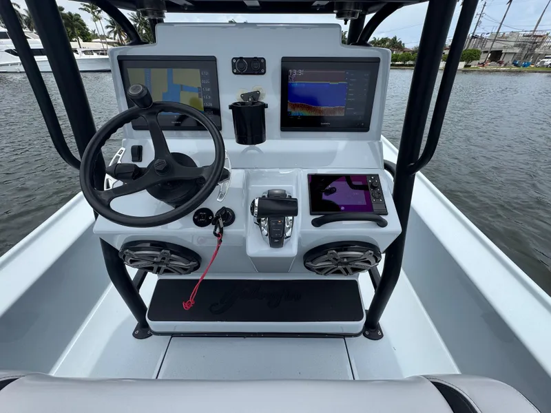 Slide: The Image of 2019 Yellowfin 24 Bay CE boat dashboard with steering wheel and navigation screens. - 12