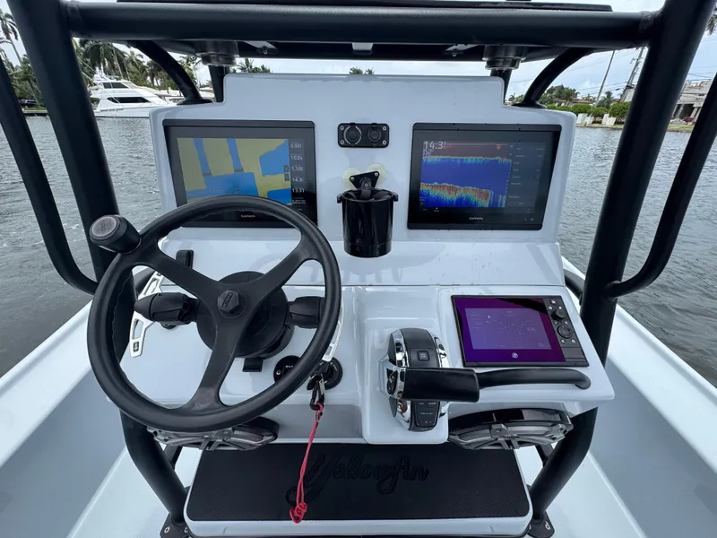 Slide: The Image of 2019 Yellowfin 24 Bay CE boat dashboard with navigation screens and steering wheel. - 13